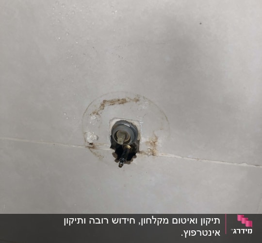 ברז מים חשוף בקיר אריחים לבן